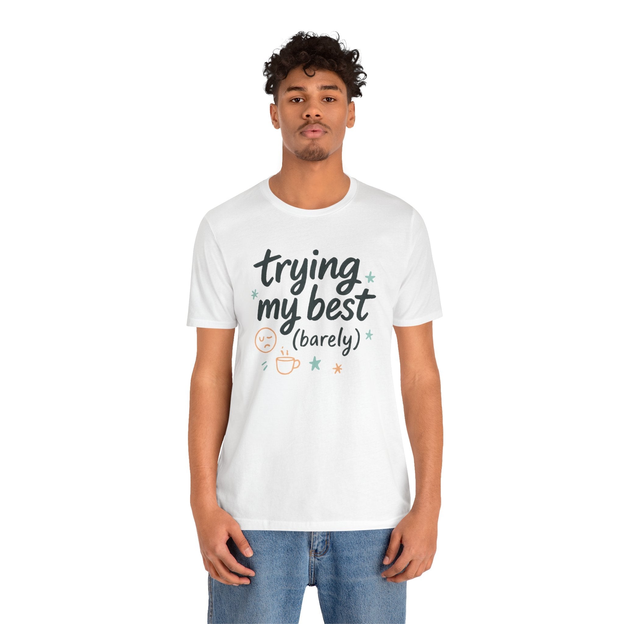 Unisex white tee with trying my best barely quote and small stars, sleepy face, and steaming mug graphic, casual fit on male model