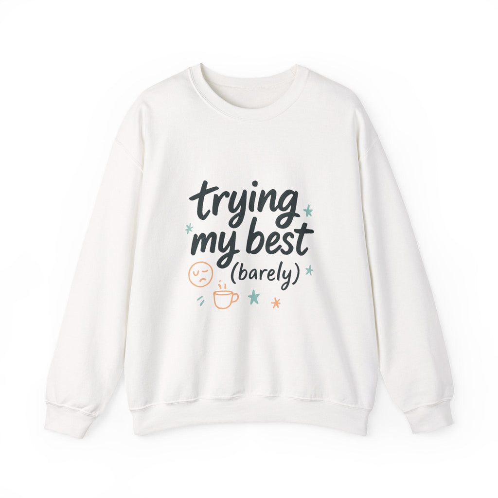 White cozy crewneck sweatshirt with "trying my best (barely)" hand-lettering, sleepy smiley, stars, and steaming mug design